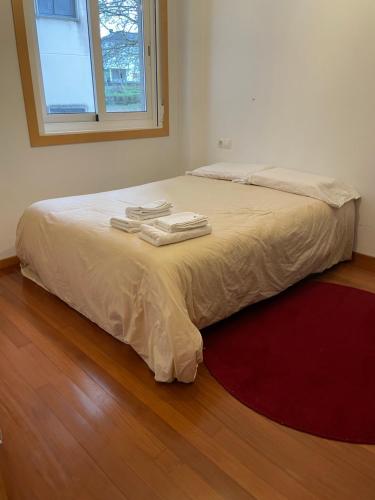 een slaapkamer met een bed met twee handdoeken erop bij Apartamento luminoso y acogedor in Lalín