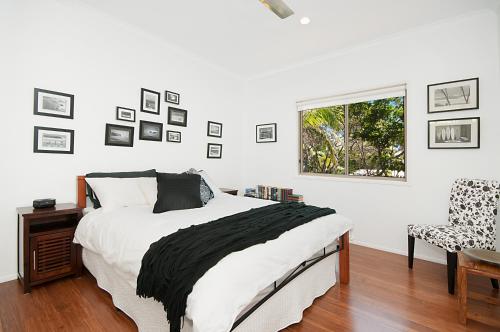 a bedroom with a bed and a window and a chair at Byron Bay Accom - Alkira 1/32 Alcorn St in Suffolk Park