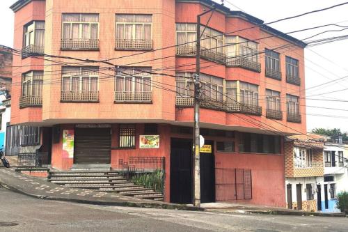 ein rotes Backsteingebäude mit einer Treppe davor in der Unterkunft Alojamiento cómodo en el centro de la ciudad. in Pereira