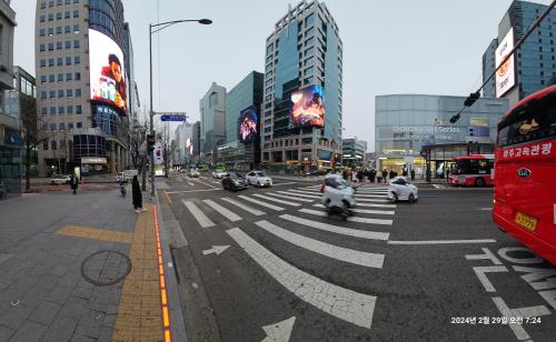 a busy city street with cars and motorcycles on the road at Hongdae Residence-5 1min from Hongik Uni station Exit #1 in Seoul