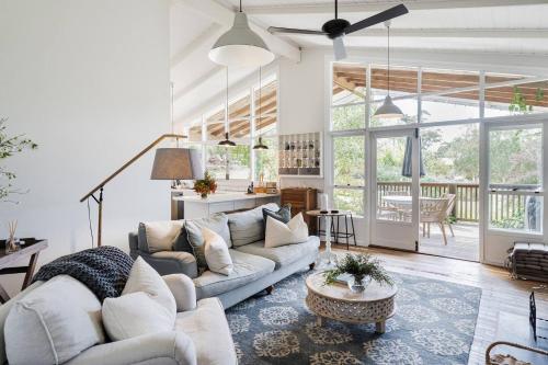 a living room with a couch and a table at Cottage Enchantment - A Blooming Garden Getaway in Red Hill South