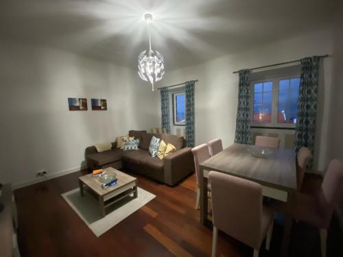 a living room with a couch and a dining room table at Alojamento Quadros in Horta
