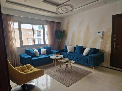 a living room with a blue couch and a table at Appartement proche de la plage in Bizerte