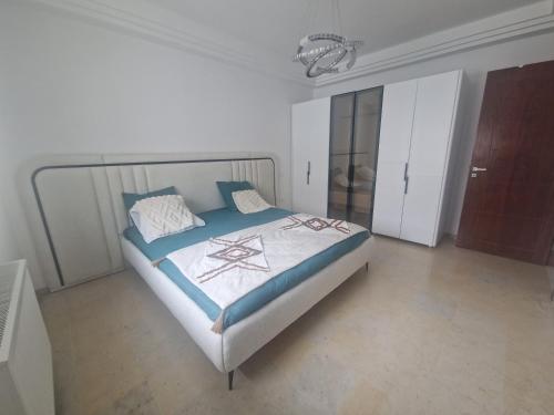 a bedroom with a bed in a white room at Appartement proche de la plage in Bizerte