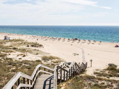 a beach with a wooden boardwalk leading to the ocean at Casa do Mar in Sesimbra