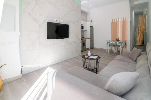 a living room with a couch and a tv on a wall at The Safe Point Suites Tablero in El Tablero