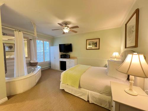a bedroom with a bed and a tub and a television at Best Western Grandma's Feather Bed in Mendenhaven