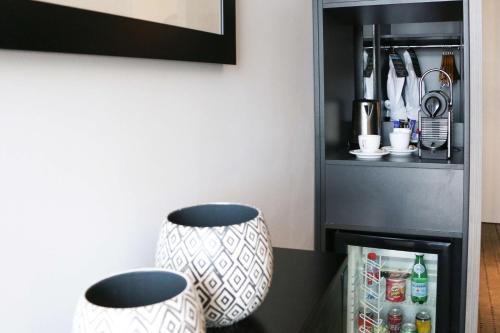 two vases sitting on a counter next to a refrigerator at Best Western Plus Hôtel & Spa de Chassieu in Chassieu