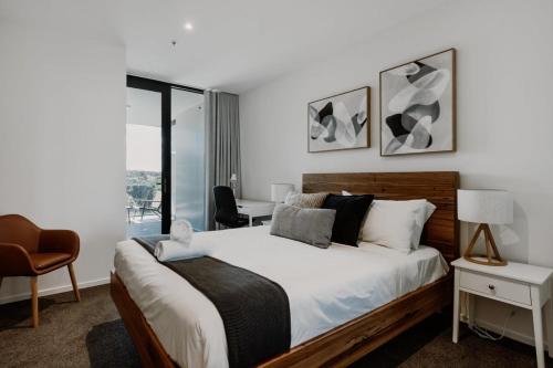 a bedroom with a bed and a desk and a window at Center 1-Bed with Gym, BBQ and Stunning Views in Canberra