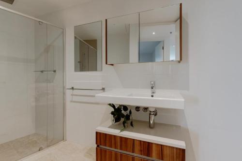 bagno con lavandino bianco e doccia di Center 1-Bed with Gym, BBQ and Stunning Views a Canberra