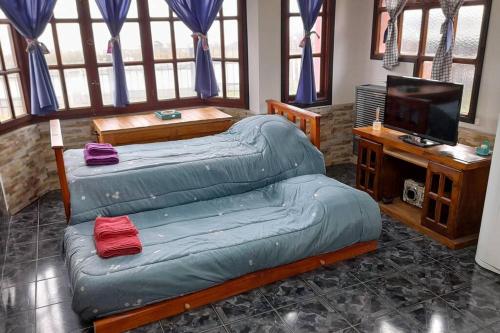 ein Schlafzimmer mit 2 Betten und einem TV. in der Unterkunft Casa Las Violetas, Ushuaia in Ushuaia