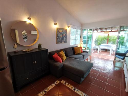 a living room with a couch and a mirror at Los Porches D40 By Pride Holiday Rentals in San Bartolomé
