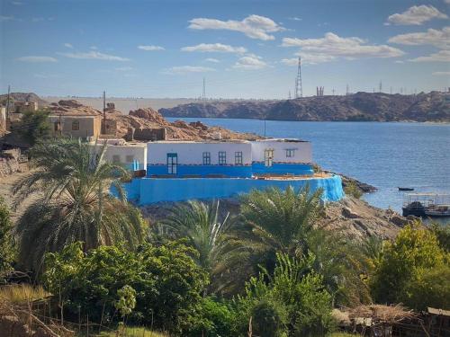 Humble Nubia في أسوان: مبنى ازرق وابيض بجانب الماء
