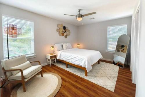 a bedroom with a bed and a chair and windows at Luxury 3BR Home Downtown Houston and near Airport in Houston