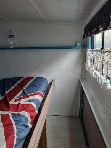 Bett in einem Zimmer mit einer amerikanischen Flaggendecke in der Unterkunft Péniche chez Léa in Béthune