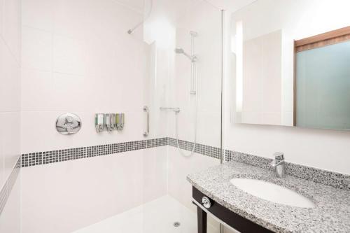 a white bathroom with a sink and a mirror at Hampton by Hilton Sheffield in Sheffield