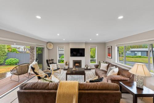 a living room with a couch and a fireplace at Bach 32 - Taupo Holiday Home in Taupo