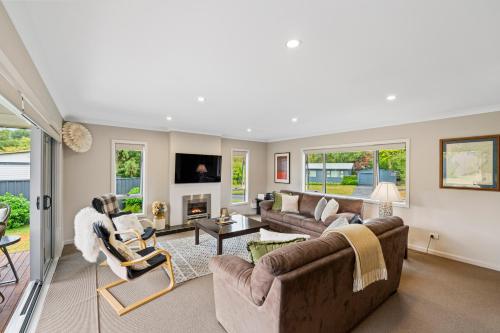 a large living room with couches and chairs at Bach 32 - Taupo Holiday Home in Taupo