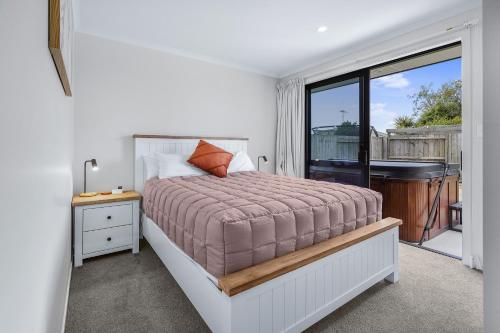 a bedroom with a bed and a balcony with a piano at The Tree House - Hamilton Holiday Home in Hamilton