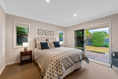 a bedroom with a bed and a large window at Bach 32 - Taupo Holiday Home in Taupo