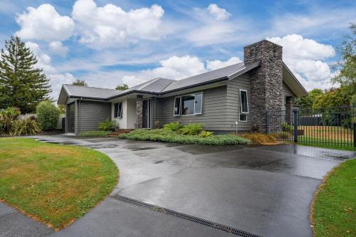 a house with a driveway in front of it at Bach 32 - Taupo Holiday Home in Taupo