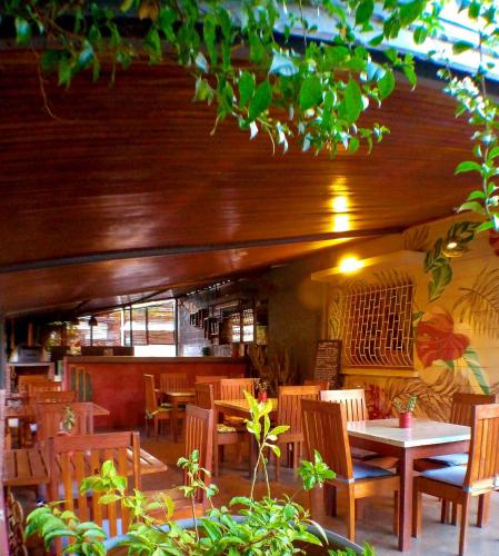 a restaurant with wooden tables and chairs and a table at L'anis Etoilé - Hôtel Restaurant in Antsirabe