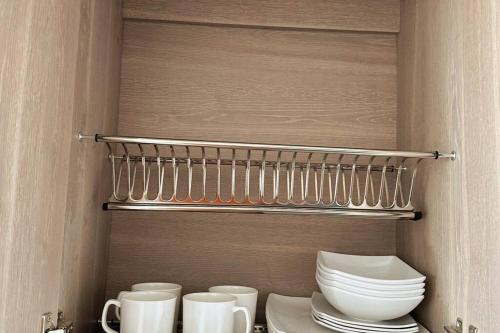 a kitchen with plates and cups on a shelf at Apartamento cerca al malecón de Barranquilla in Barranquilla