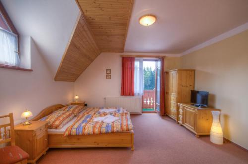 a bedroom with a bed and a tv in it at Harrachovská Hacienda in Harrachov