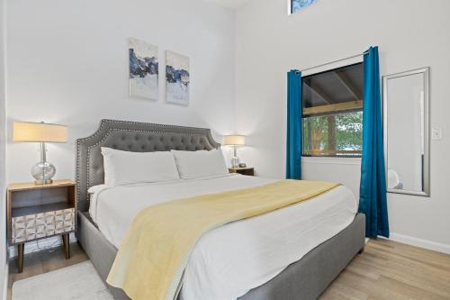 um quarto com uma cama grande e uma janela em Bluebonnet Waterfront Cottage with Hot Tub em Fredericksburg