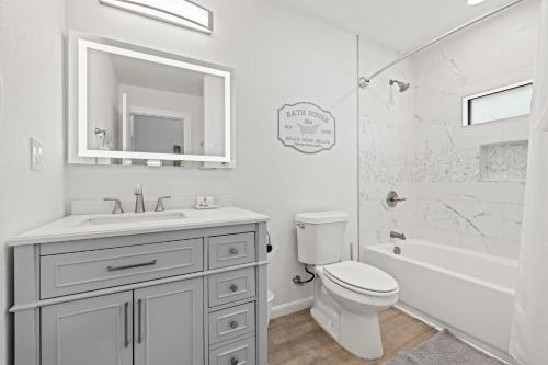 een witte badkamer met een wastafel en een toilet bij Primrose Waterfront with Hot Tub in Tivydale