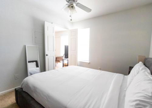 sypialnia z białym łóżkiem i wentylatorem sufitowym w obiekcie Wyndham 108 Corporate & Modern 1br Suite w mieście Hampton