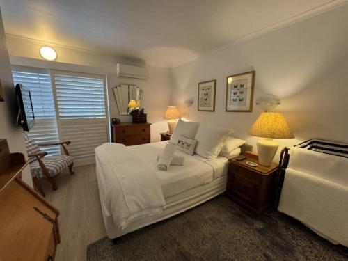 um quarto com uma cama e uma mesa com 2 candeeiros em 2 BR Cotton Tree Coastal Charm em Maroochydore