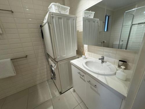 uma casa de banho branca com um lavatório e um frigorífico em 2 BR Cotton Tree Coastal Charm em Maroochydore