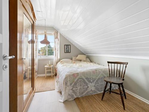 ein Schlafzimmer mit einem Bett und einem Stuhl im Dachgeschoss in der Unterkunft skogro in Fredrikstad