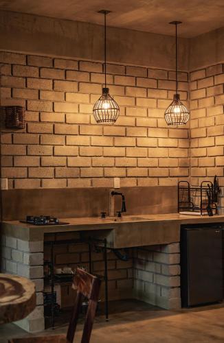 a kitchen with a sink and two pendant lights at Villa Macarena Apartamentos Boutique - Only Adults in Puerto Escondido