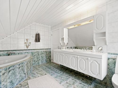 ein weißes Badezimmer mit einer Badewanne und einem Waschbecken in der Unterkunft skogro in Fredrikstad