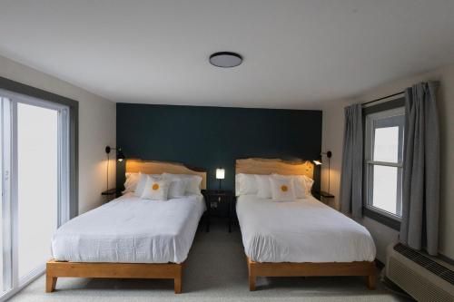 a bedroom with two beds and a green wall at East Rock Inn in Great Barrington