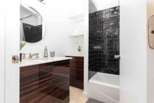 a bathroom with a tub and a sink and a mirror at 1-BR Apartment Downtown Miami - Heart of Wynwood and Midtown in Miami