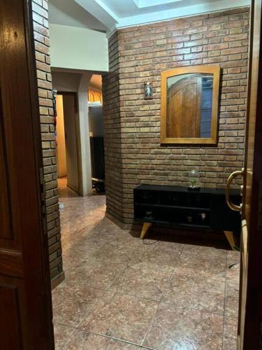 La salle de bains est pourvue d'un mur en briques et d'un miroir. dans l'établissement Casa Lugones, à La Cieneguita