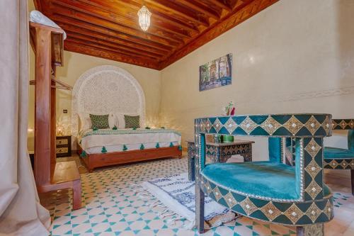 a room with two beds and a chair in it at Riad Amalia in Marrakech