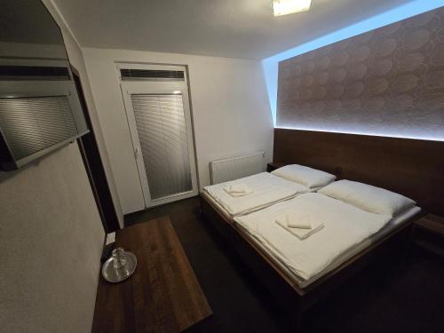 a small bedroom with a bed and a window at Penzión Arizona in Zlaté Moravce