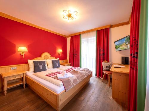 a bedroom with a bed with a red wall at Winter Chalet Kaprun in Kaprun