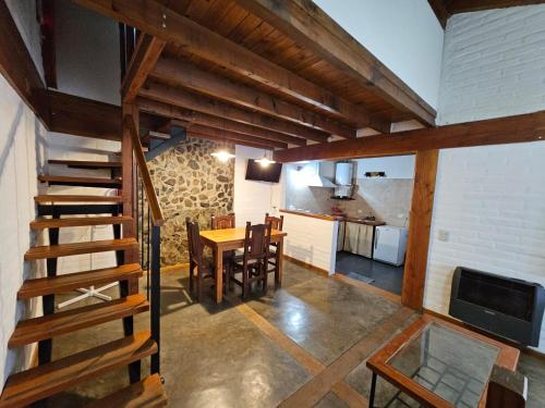 a kitchen and dining room with a staircase in a house at Punto Sur Cabañas in El Bolsón
