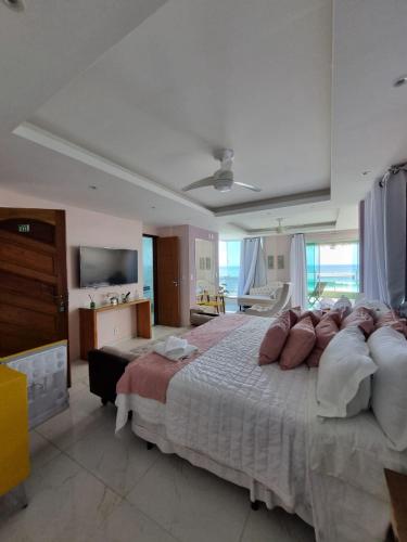 a large bedroom with a large bed and a television at Hotel Aconchego Da Vila in Saquarema