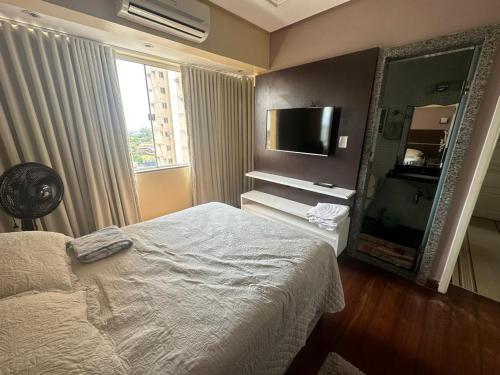 um quarto com uma cama, um espelho e uma televisão em Apartamento Completo Próx Hangar em Belém