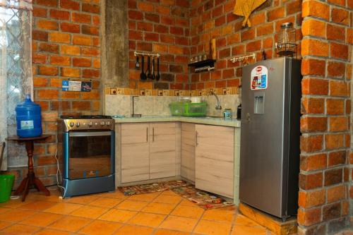 eine Küche mit Ziegelwand und Kühlschrank in der Unterkunft Casa Ensueño in Catamayo