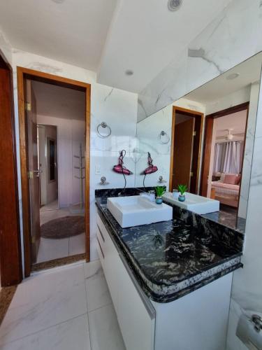 a bathroom with two sinks and a large mirror at Hotel Aconchego Da Vila in Saquarema