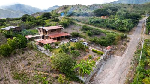 a house on a hill next to a dirt road at Casa Ensueño in Catamayo
