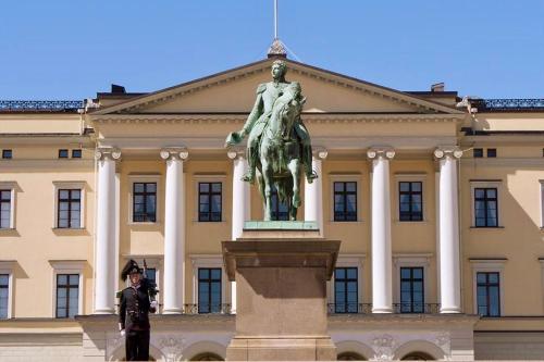 a statue of a man on a horse in front of a building at Frogner Park Penthouse Terrace in Oslo