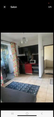 a living room with a kitchen with a rug on the floor at Le Ti Coin à Didy in Fort-de-France